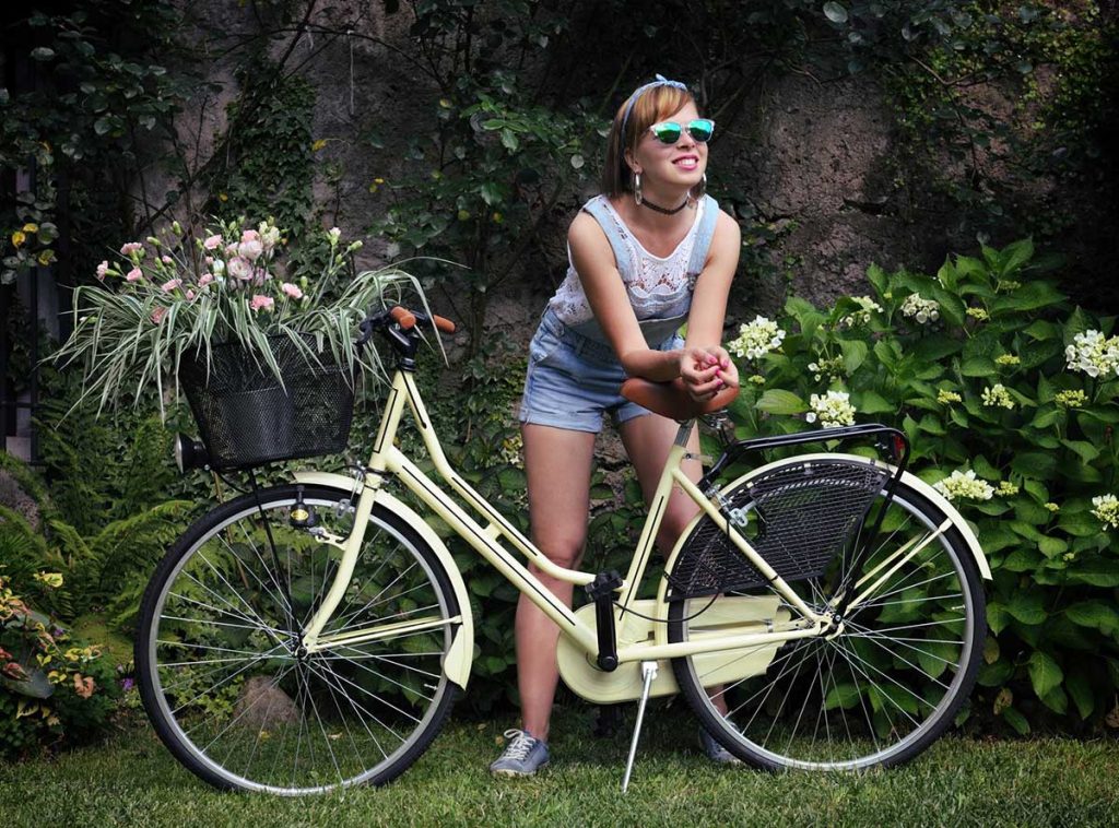 girl standing beside a bicycle with gps tracker installed in the cycle