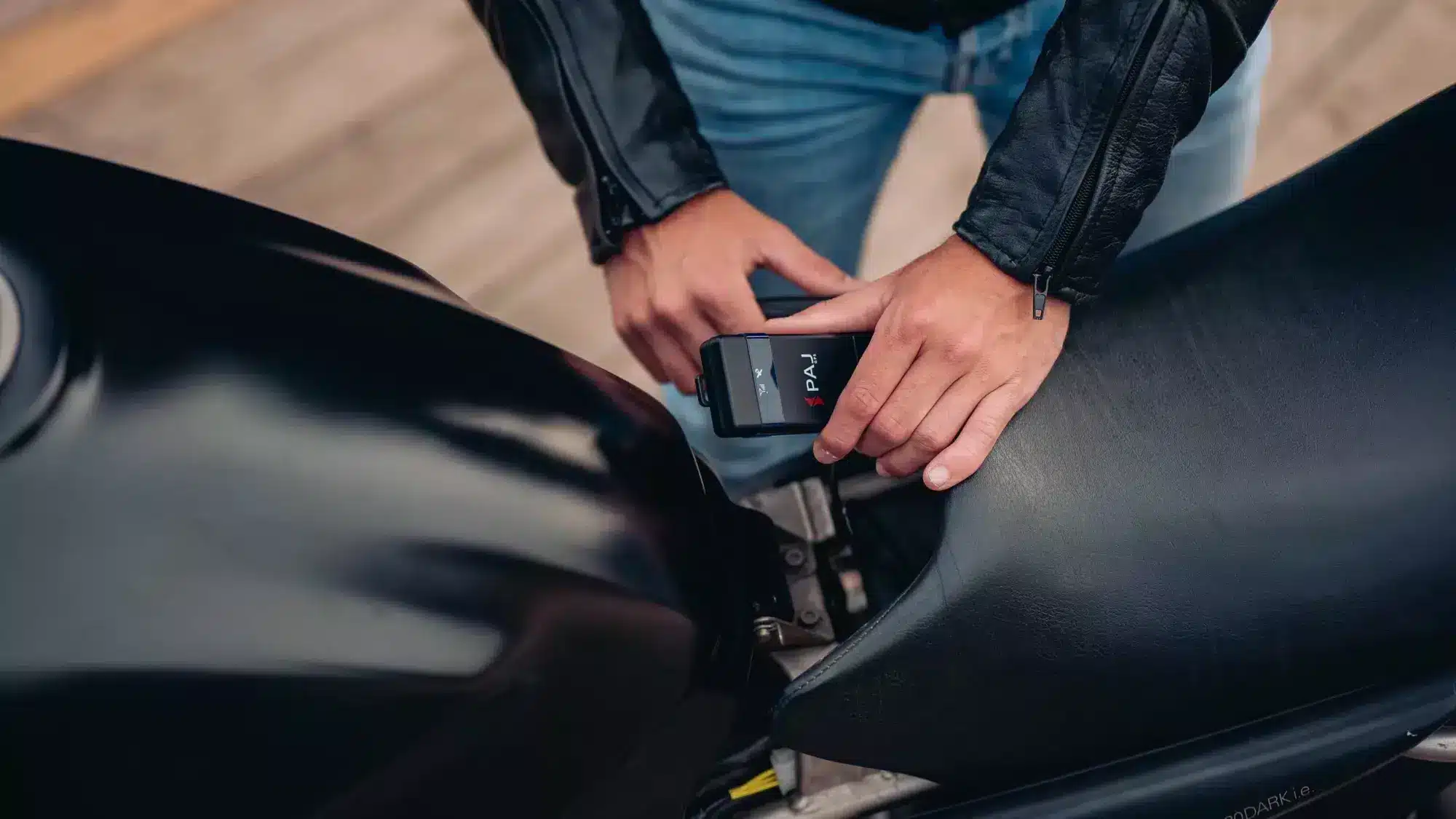 A man safely placing motorcycle gps tracker